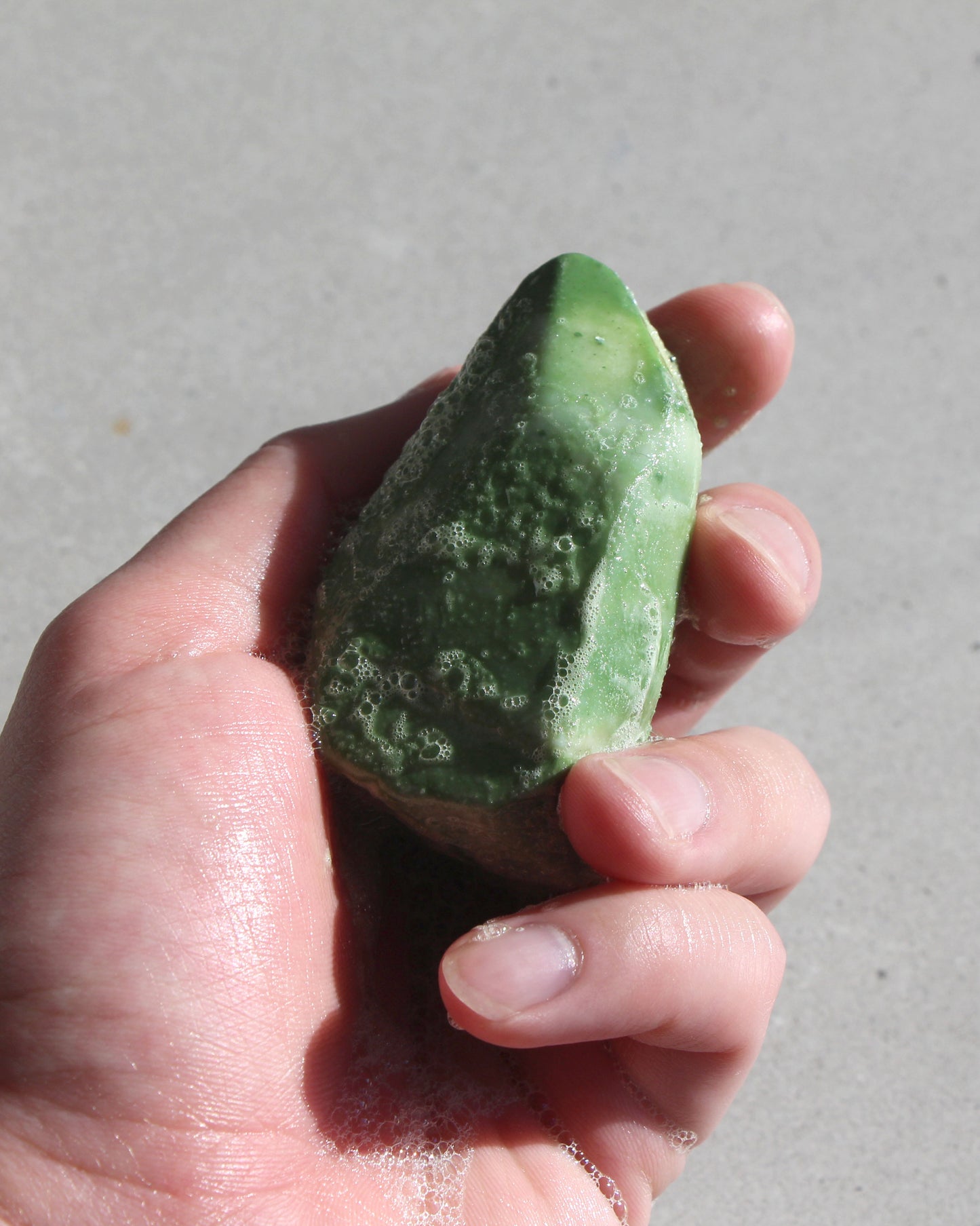 Green shampoo bar lathered in hand