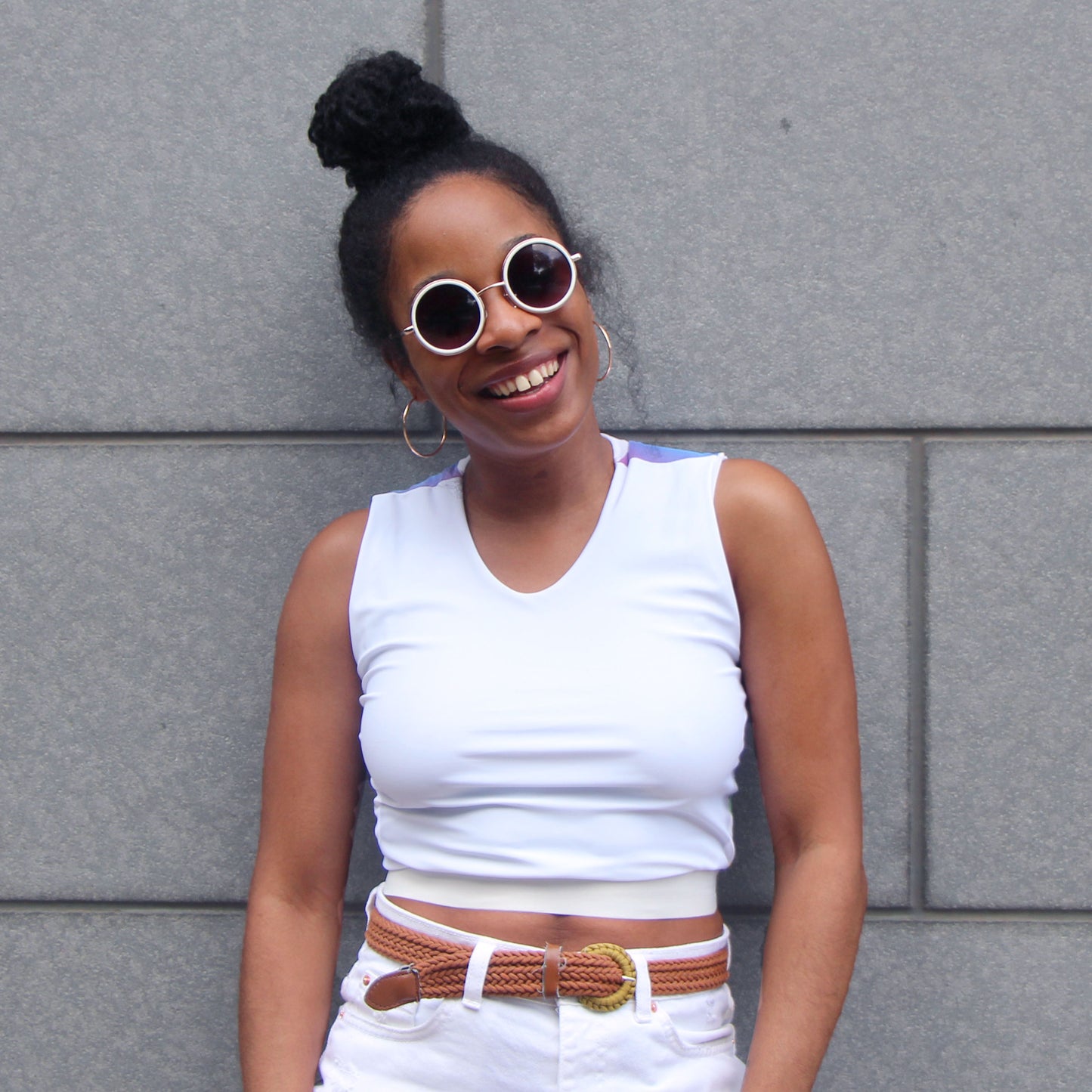 A woman smiling wearing a white croptop