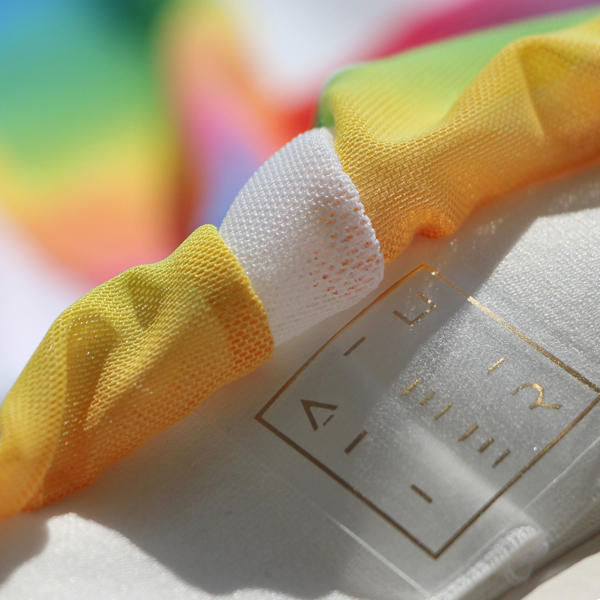 Closeup photo of rainbow mesh back and gold logo